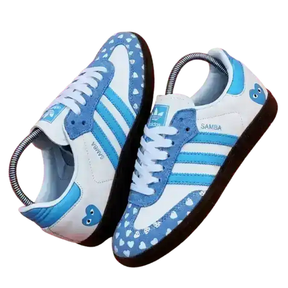 Light blue and white Adidas Samba OG shoes customized with a heart print suede toe cap and heart logo on the heel.